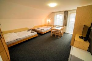 Cette chambre comprend 2 lits, une table et une télévision. dans l'établissement Pension 222 - Family rooms in Vrchlabi, à Vrchlabí