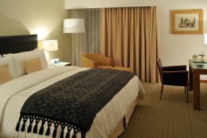 a hotel room with a large bed and a desk at Presidente Intercontinental Puebla, an IHG Hotel in Puebla