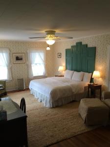 a bedroom with a large bed with a green headboard at House on Chase Creek in Shelter Island Heights