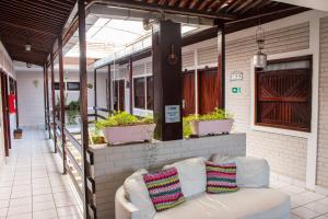 a white couch sitting on a porch with plants at Hotel Pousada Da Sereia in Maceió