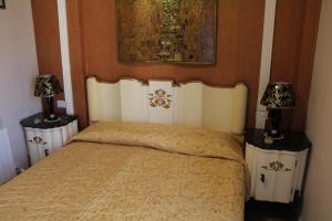 um quarto com uma cama com duas mesas de cabeceira e dois candeeiros em B&B Giorno e Notte em Pisa