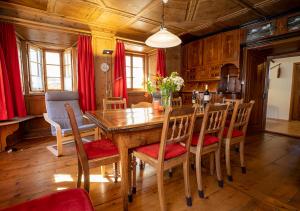 een eetkamer met een houten tafel en stoelen bij Chasa Werro in Sent