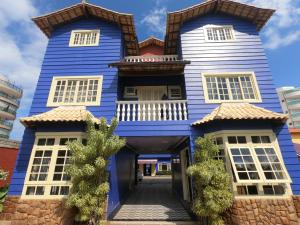 une maison bleue et blanche avec une allée dans l'établissement Pousada Portal do Mar, à Cabo Frio