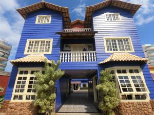 una casa azul y blanca con entrada en Pousada Portal do Mar, en Cabo Frío