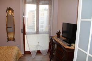 um quarto com uma janela, uma cama e uma televisão em B&B Giorno e Notte em Pisa