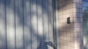a white tiled wall next to a building at Edifício Belio in Cascavel