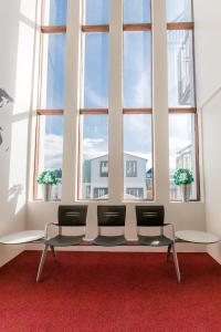 a waiting room with four chairs in front of a large window at Hotel Keilir by Reykjavik Keflavik Airport in Keflavík