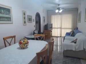 ein Wohnzimmer mit einem Tisch und einer Schale Bananen darauf in der Unterkunft Apartamento para 6 pessoas a 10m da praia in Praia Grande