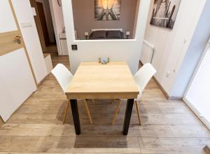 a table and chairs in a room with a bed at Tymon Apartament przy deptaku in Szczawno-Zdrój +10 photos