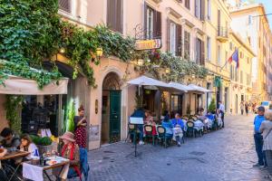 um grupo de pessoas sentadas em mesas numa rua em Domus De Fiori em Roma
