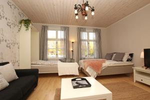 a living room with a bed and a couch at Idyllic central wooden house apartment in Pori