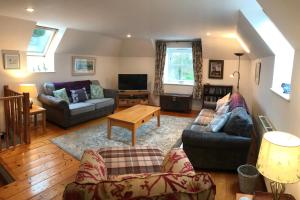 a living room with two couches and a tv at The Steadings Cottage in Chesters