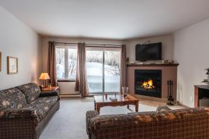 a living room with two couches and a fireplace at Aiglon by Rendez-Vous Mont-Tremblant in Mont-Tremblant