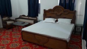 a bedroom with a large bed with a wooden headboard at Royal Panorama in Jodhpur