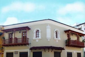 Una gran casa blanca con balcones en una calle en ETHNIC Thematic Hotel, en Cartagena de Indias