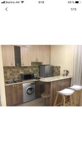 a kitchen with wooden cabinets and a sink and a dishwasher at Уютная квартира около станции метро in Yerevan