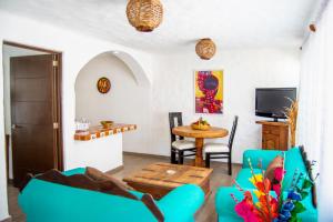 a living room with blue chairs and a table at Petit Hotel Pilitas in Puerto Vallarta