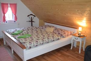 1 dormitorio con 1 cama y 1 mesa con lámpara en chalupa U Troubilů en Rváčov