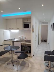 a kitchen with white cabinets and black chairs and a table at Potal in Cuffies