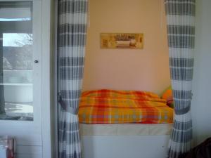 ein kleines Bett in einem Zimmer mit Fenster in der Unterkunft Geeste 1 in Bremerhaven