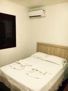 a bedroom with a bed with a air conditioner on the wall at Apartamento a DUAS quadras do Centro in Gramado