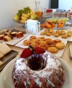 a table with a doughnut on a plate with strawberries at Hotel Muralha in São Lourenço do Sul