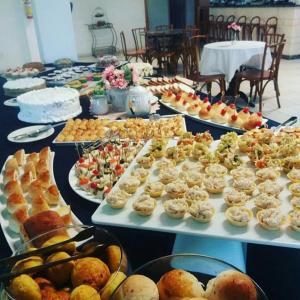 a table filled with different types of pastries and desserts at Hotel Muralha in São Lourenço do Sul