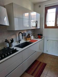 a kitchen with white cabinets and a sink at Marconi 45 in Osmate Lentate