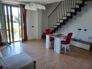 a living room with a table and chairs and stairs at Marconi 45 in Osmate Lentate