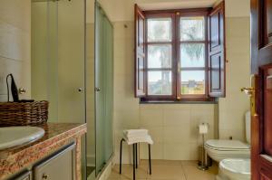 een badkamer met een douche, een toilet en een raam bij B&B La Torretta in Loano