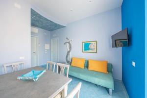 ein Wohnzimmer mit einem blauen Sofa und einem Tisch in der Unterkunft La Casa del Poeta - Appartamento Positano in Maiori