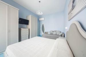 a white bedroom with a bed and a couch at La Casa del Poeta - Appartamento Positano in Maiori