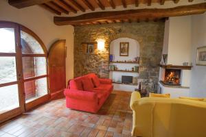 a living room with a red chair and a fireplace at Podere Pietreta in Radicofani