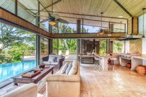 Villa La Loma في جاكو: غرفة معيشة مفتوحة مع مسبح ومنزل