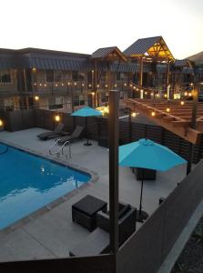 a patio with umbrellas and a swimming pool at The Hotel Y in Yakima