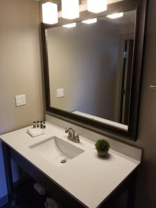 a bathroom with a sink and a large mirror at The Hotel Y in Yakima