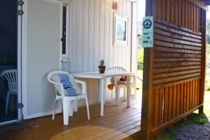 a patio with a table and chairs on a deck at Brisas Mágicas in Punta Del Diablo