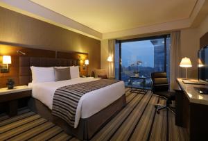 メキシコシティにあるJW マリオット ホテル メキシコ シティ サンタ フェのベッド、デスク、窓が備わるホテルルームです。