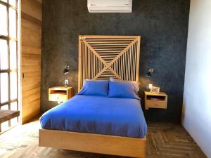 a bedroom with a large bed with a wooden headboard at Canela Fina - Adults Only in San Miguel de Allende