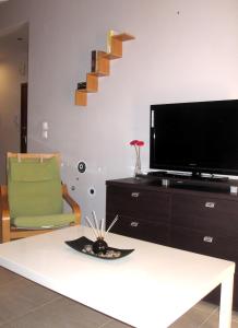 sala de estar con TV de pantalla plana y mesa en City Center Martha's Apartment, en Tesalónica