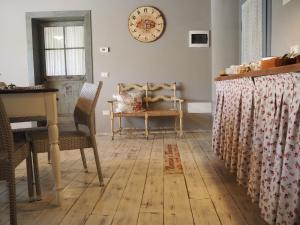 a room with a table and chairs and a clock on the wall at B&B Antique Maison in Soave