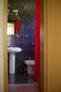 baño con lavabo, aseo y cortina roja en Tourist Farm Rooms Lovrec, en Jiršovci