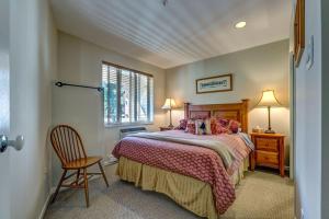 a bedroom with a bed and a chair and a window at Town Plaza Suites by Golden Dreams in Whistler