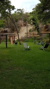 a group of chairs sitting in the grass at Cabañas Victoria in Mar de las Pampas