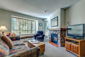 a living room with a couch and a tv and a fireplace at Town Plaza Suites by Golden Dreams in Whistler