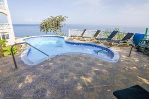 una piscina con sillas y el océano en el fondo en Home Sweet Home Resort, en Negril