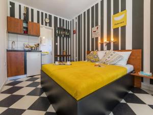 a bedroom with a bed with a yellow blanket at Apartments Rabbit in Crikvenica