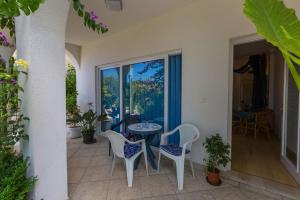 a patio with a table and chairs and a window at Apartments Dorijan i Karlo in Selce