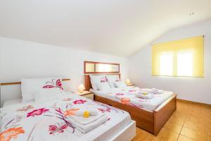 Dos camas en una habitación con paredes blancas. en Apartment Lorena, en Dramalj