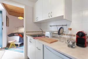 une cuisine avec des placards blancs et un comptoir dans l'établissement Alfama Charming Apartment, By TimeCooler, à Lisbonne